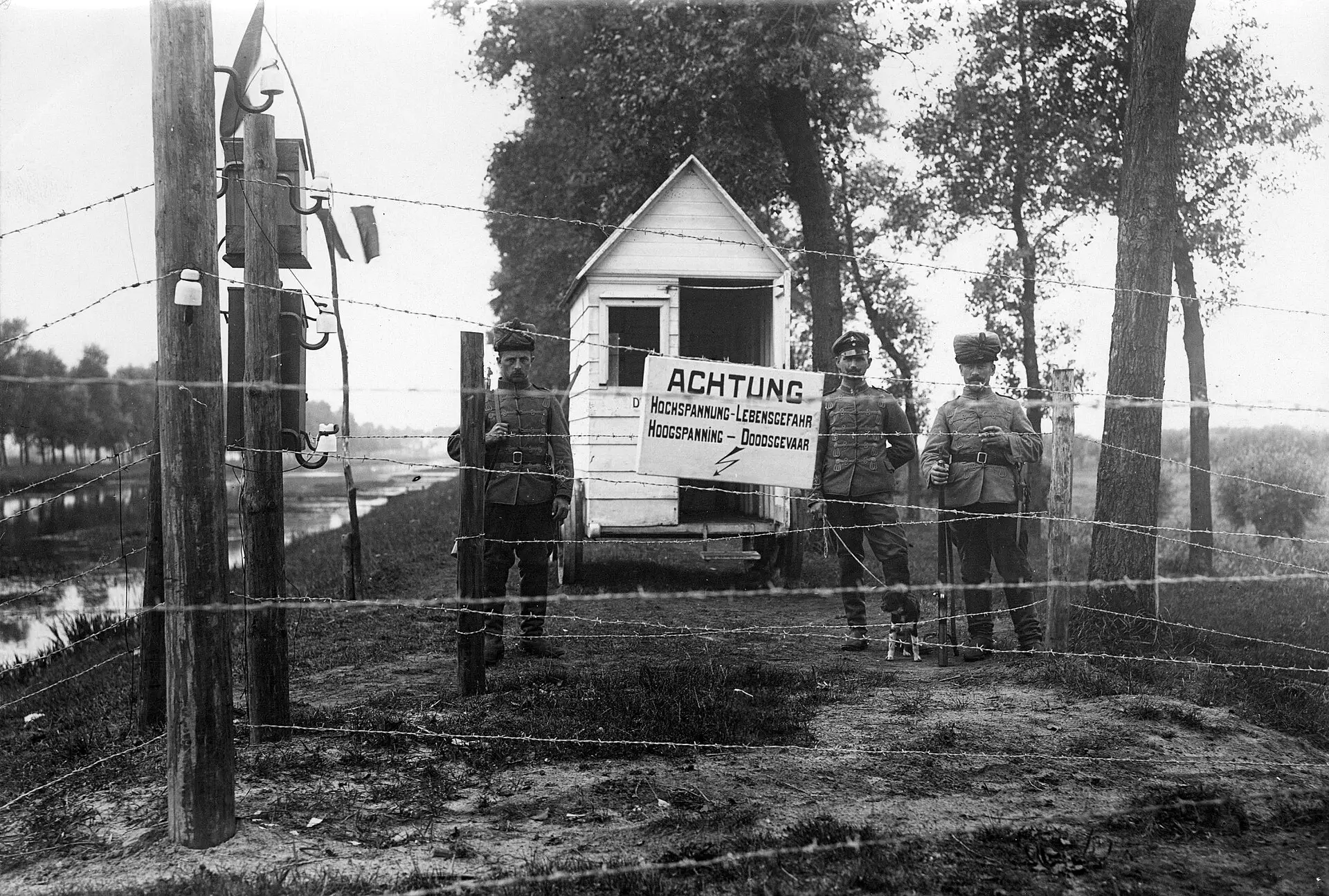 Archieffoto, 1915–1918: Duitse wachten bij een ‘Achtung’-bord aan de geëlektrificeerde Doodendraad